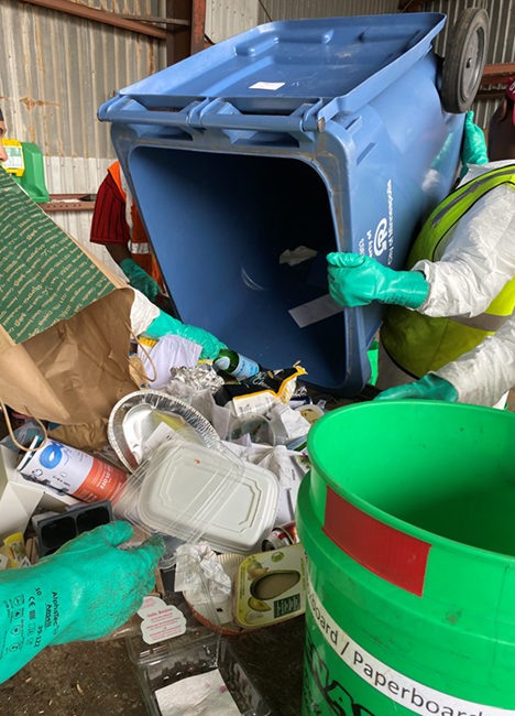 recycling cart contents dumped onto waste sorting table