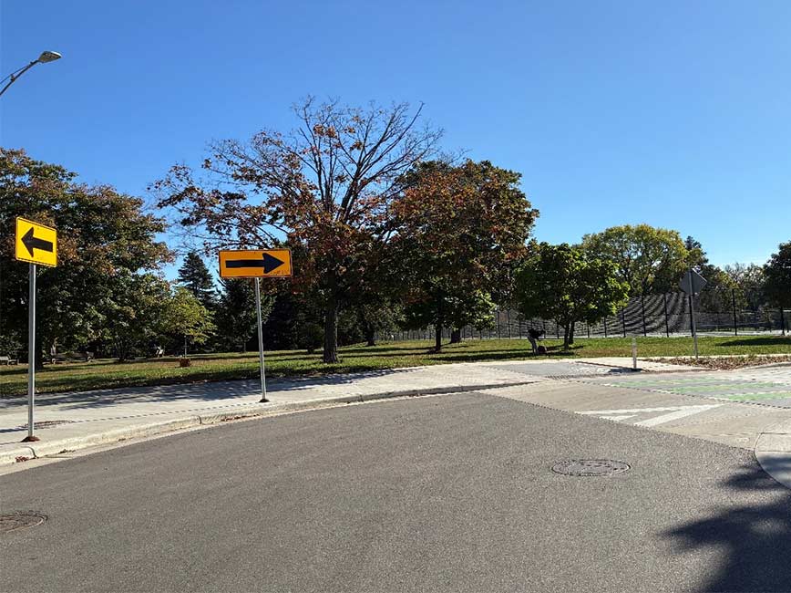 Tree lined street curving around a bend in the road.
