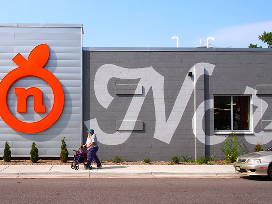 A person using a walker on the sidewalk