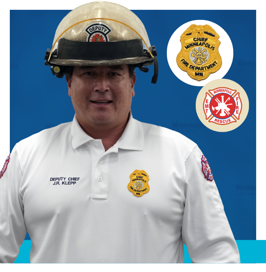 Deputy Fire Chief wearing white shirt with helmet and badges Deputy Fire Chief wearing tan uniform with helmet and badges that say Chief Minneapolis Fire Department MN and Minneapolis EMT Fire Rescue