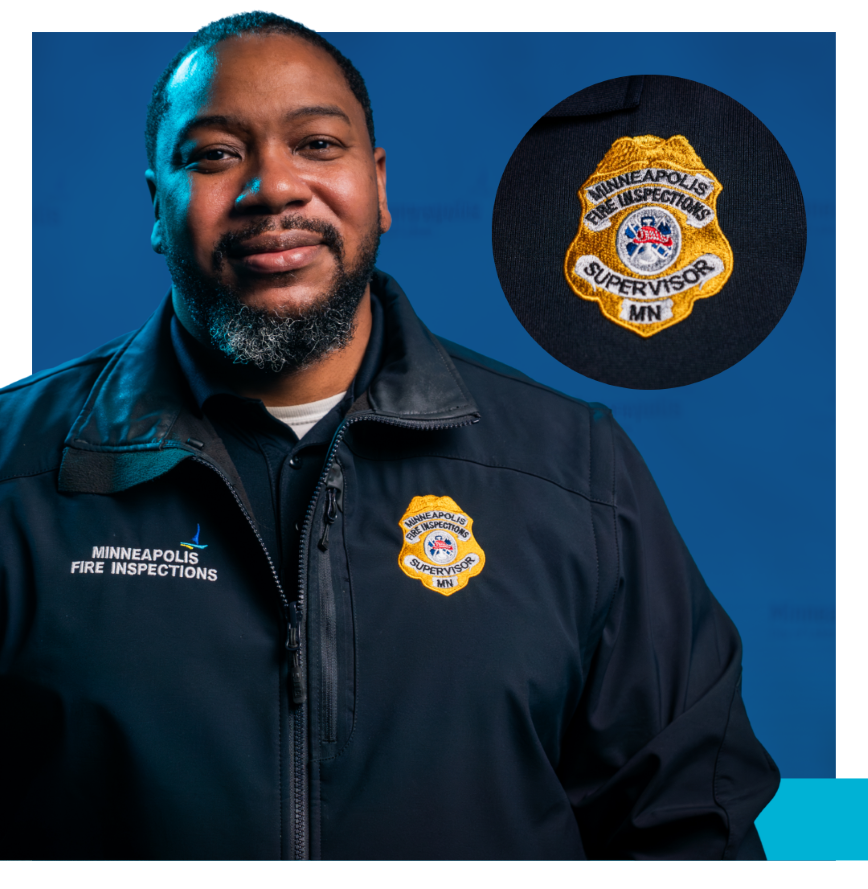 Fire Inspections Supervisor wearing navy uniform and yellow badge that says Minneapolis Fire Inspections Supervisor MN