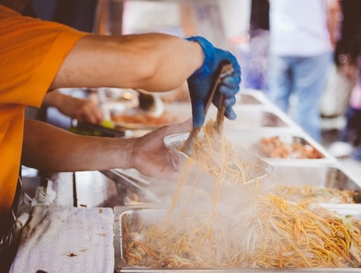Food vendor dishing up noodles at event