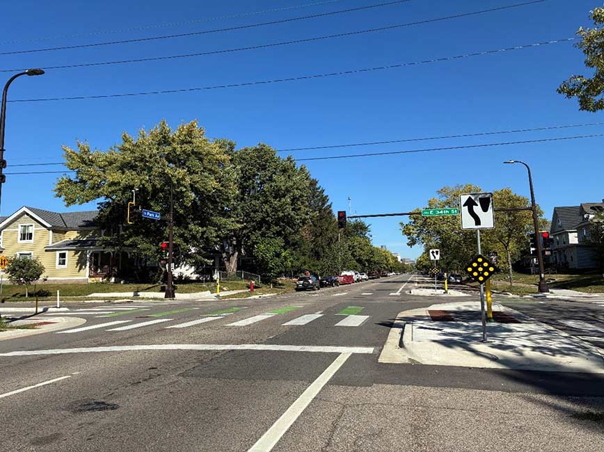 A tree-lined street with a corner bump-out for crossing.