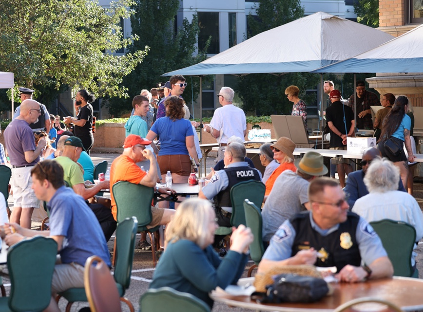 Group of people sitting at tables for National Night Out