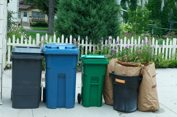 garbage, recycling, organics carts and yard waste bags outside of someone's home