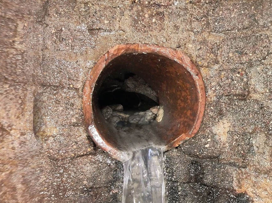 Clay pipe with water coming out of it.