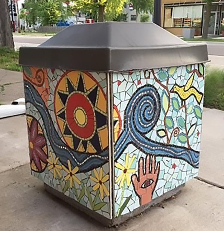 A waste container with a colorful mosaic.
