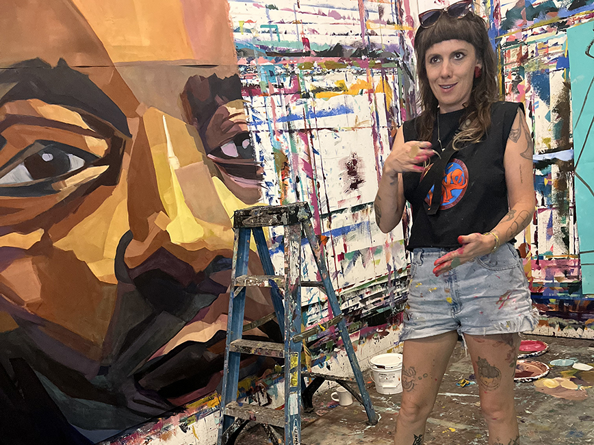 Artist talking about a large portrait in a studio.