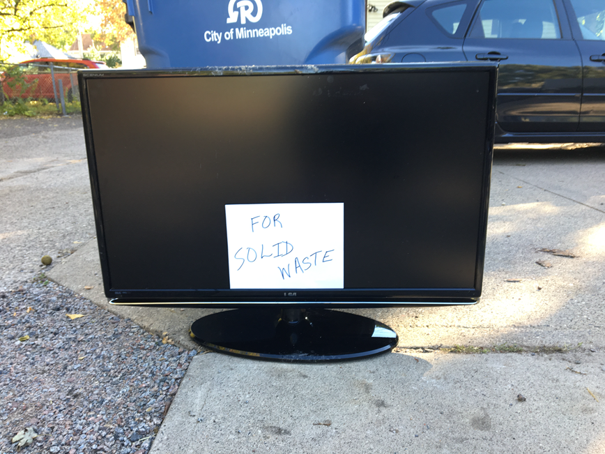 TV and keyboard labeled 'for solid waste' set out for pickup