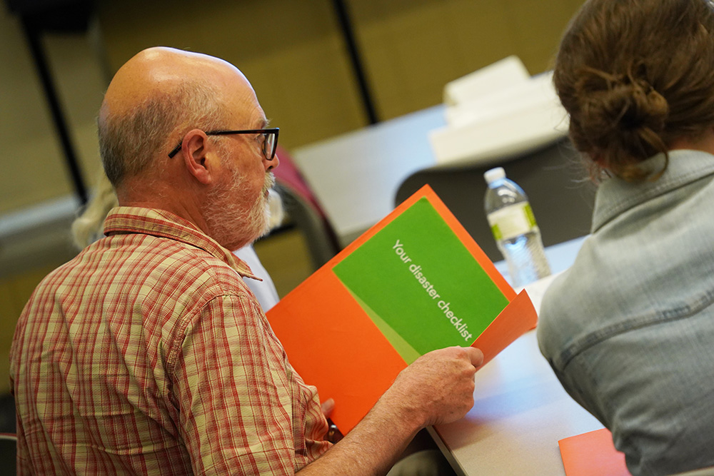 A man participates in Ready Camp and holds a disaster checklist
