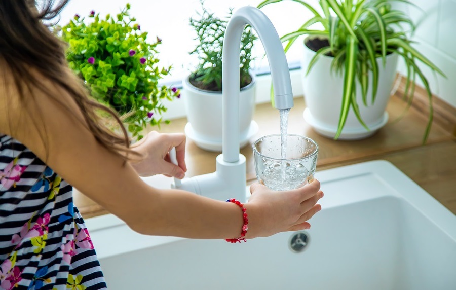Child filling up glass with tap water