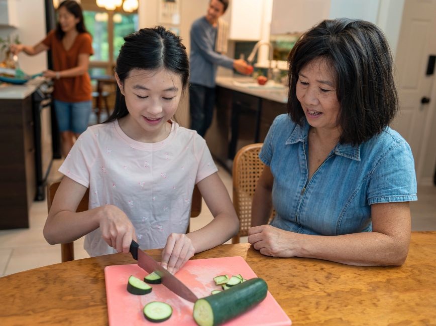 Child and adult cutting healthy food