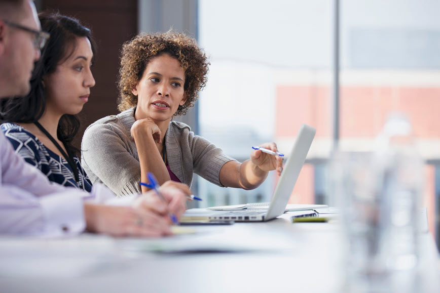 Two people talking near laptop