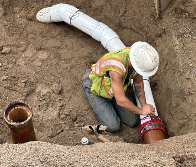 Sanitary sewer worker working on underground sewer line.
