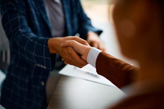Two people in business attire shaking hands