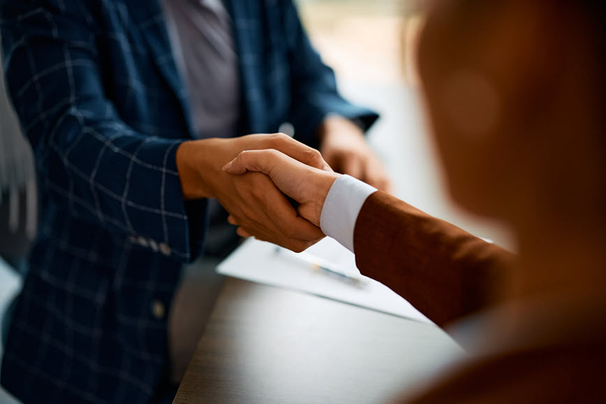 Two people in business attire shaking hands