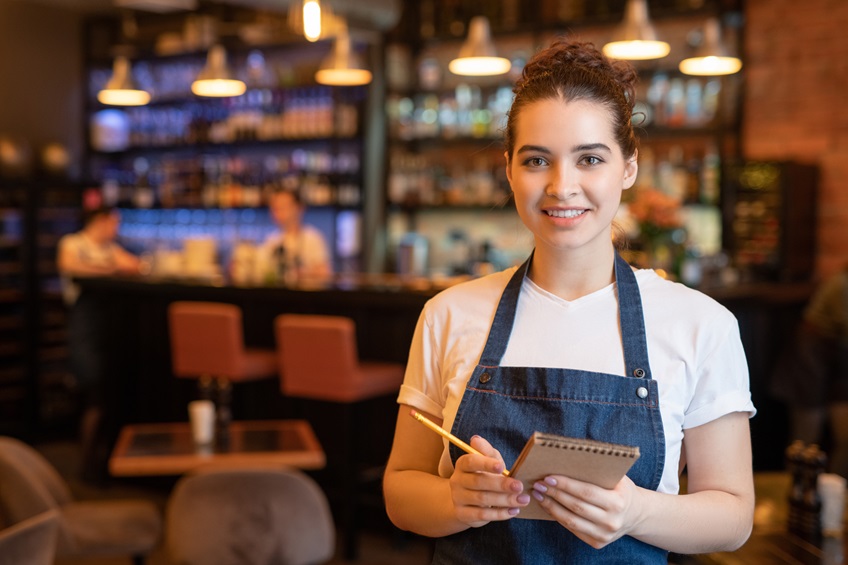 Smiling waiter with note pad