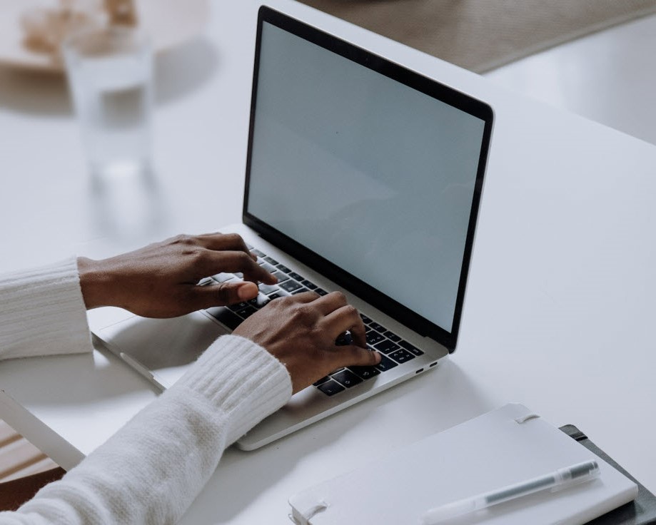 Person's hands typing on laptop.