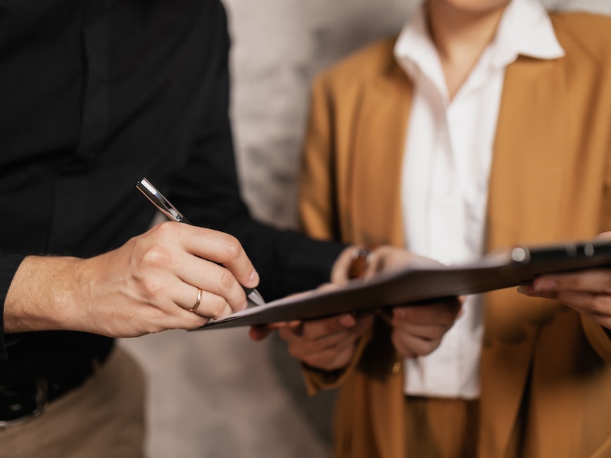 Handshake between two professionals with a person looking on.
