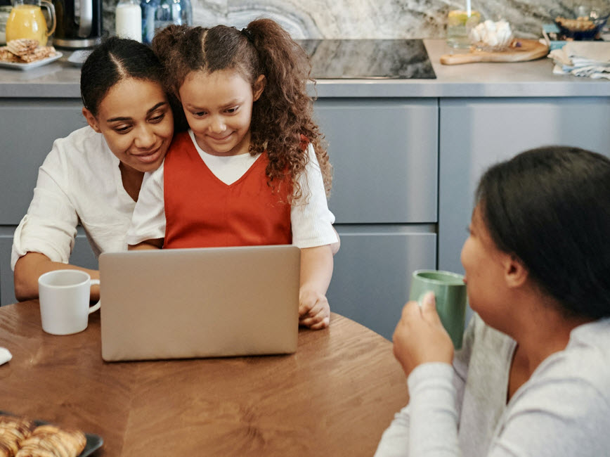 A family sitting together looking at a laptop