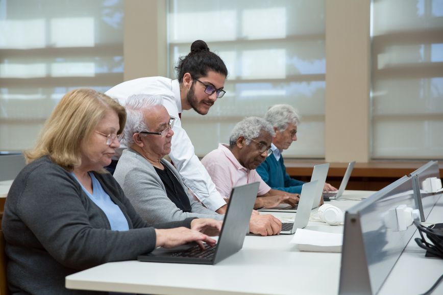 Elderly people getting help with computers